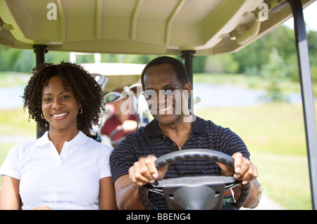 Porträt des Paares im Golf-Cart fahren Stockfoto