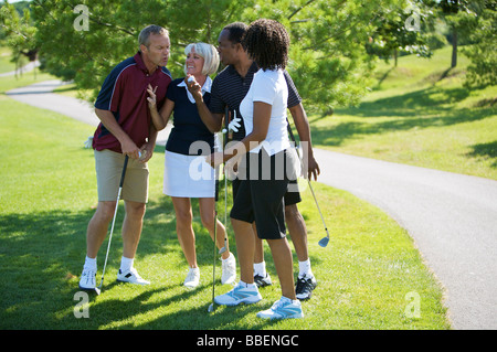 Paare im Chat auf Golfplatz Stockfoto