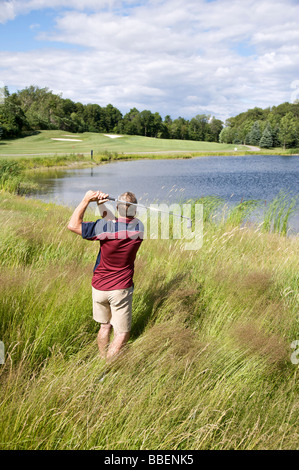 Rückansicht des Mannes Golfen in hohe Gräser Stockfoto