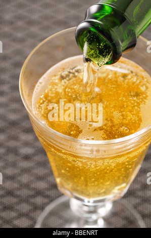 Champagner in Glas gießen Stockfoto