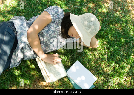 Junge Frau auf dem Boden lesen, erhöhte Ansicht liegend Stockfoto