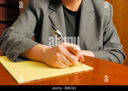 Business-Frau, die auf einem Blatt Papier zu schreiben Stockfoto