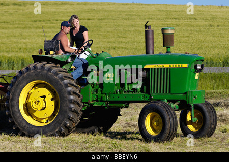 Bauer und seine Frau auf John Deere 3010 Diesel-Traktor im Harrison County Indiana Stockfoto