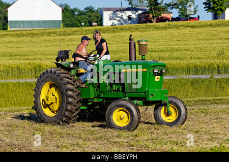 Bauer und seine Frau auf John Deere 3010 Diesel-Traktor im Harrison County Indiana Stockfoto