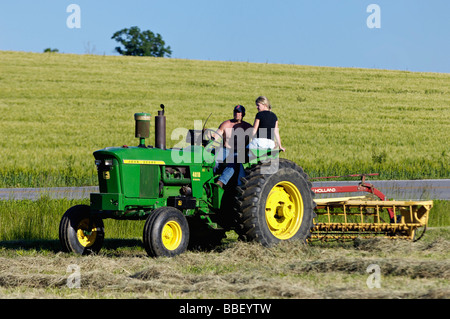 Bauer und seine Frau auf John Deere 3010 Diesel-Traktor im Harrison County Indiana Stockfoto