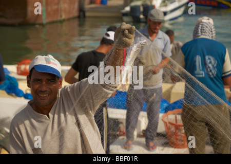 Einer der Fischer zeigt kleine Fische im Netz. Stockfoto