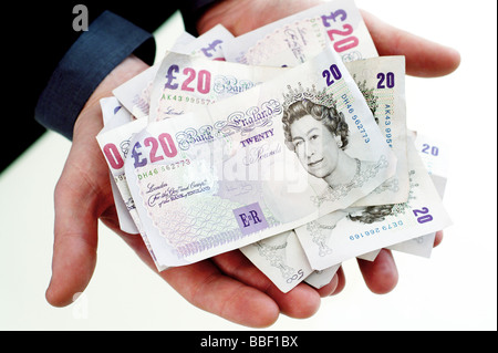 Mann hält UK Sterling-Währung in Noten wie Bargeld Stockfoto