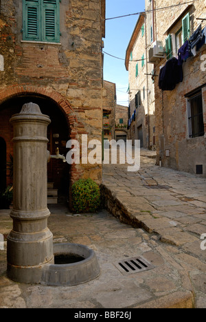 Toskana (Toscana) Italien - Blick auf einen Wasserhahn durch schmale Gasse zwischen den Gebäuden der mittelalterlichen Stadt Casale Marittimo Stockfoto