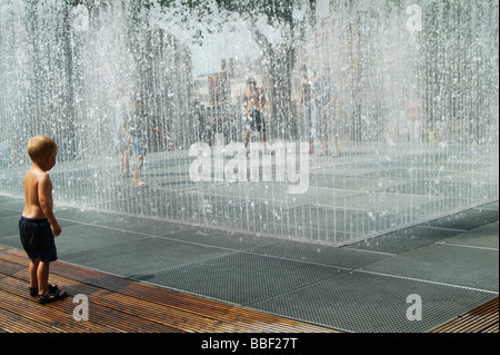 Kleiner Junge spielt in der Wasser-Brunnen in England UK Stockfoto