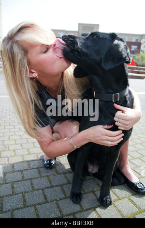 Blondine mit weißen kaukasischen Frau mit schwarzen Labrador Hund in eine urbane Parklandschaft. Stockfoto