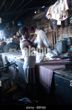 ein indischer Mann Bügeln der Kleidung auf der Mumbai-Waschsalon Dhobi Ghats Stockfoto