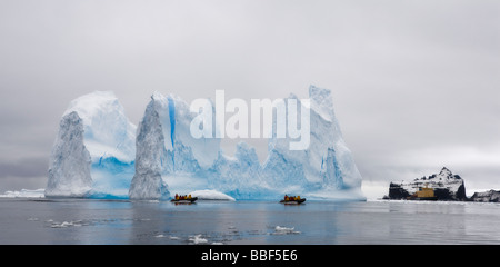 Panorama Passagiere in Zodiac Fahrt neben großen blauen Eisberge in Bellinghausen Meer westlichen Antarktis Eisbrecher Kreuzfahrtschiff im Hintergrund für Skalierung Stockfoto