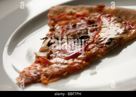 Pizza mit Pilzen und Zwiebeln auf einem weißen Teller. Stockfoto