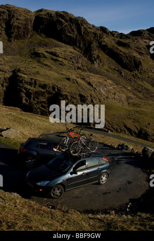 Autofahrer kämpfen, um die Kurven auf den Steilstrecken Hardknott Pass im Lake District zu verhandeln Stockfoto