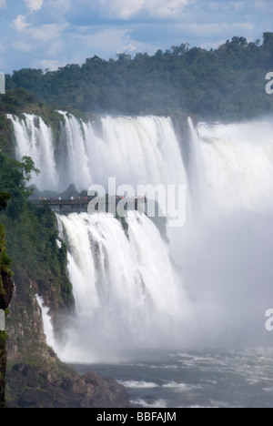 Mit Blick auf die brasilianische Seite der Iguazu fällt aus Argentinien. Touristen stehen auf der Aussichtsplattform mit Blick auf die Wasserfälle. Stockfoto