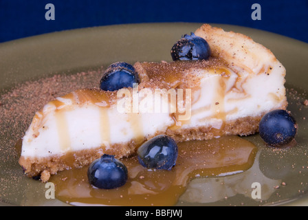 Ein Stück Karamel beschichteter Käsekuchen mit Blurberries und Muskatnuss Streusel Stockfoto