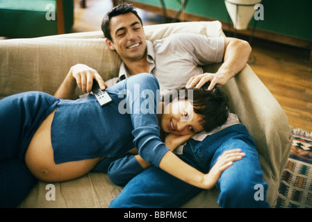 Werdende paar gemütlich auf Sofa, Fernsehen, Frau Kopf im Schoß des Mannes Stockfoto