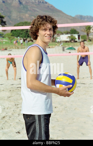 Männchen halten Volleball, Beachvolleyball spielen Stockfoto