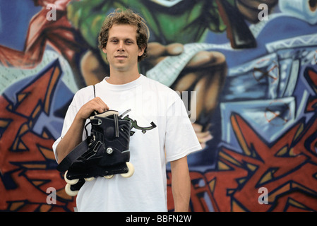 Männchen mit paar Inline-skates schwebt über der Schulter, der vor Fototapeten Stockfoto
