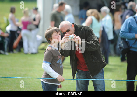 Vater und Sohn eine kompakte digital Camer zusammen mit einem Dorffest. Bild von Jim Holden. Stockfoto