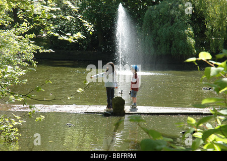 Zwei Kinder am Teich und Wasser Brunnen in den botanischen Gärten in Churchtown, Southport, Merseyside Stockfoto