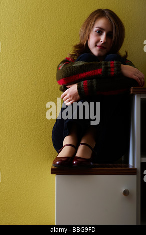 Junges Mädchen sitzt auf einem Schritt Stockfoto