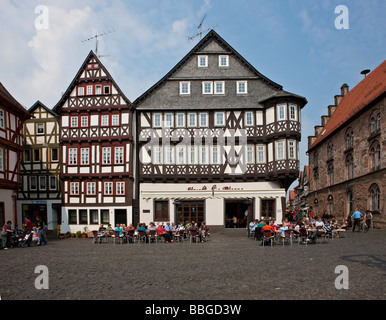 Touristen sitzen in der Sonne auf dem Marktplatz vor ein Kaffeehaus, Altstadt, Alsfeld, Hessen, Deutschland, Europa Stockfoto