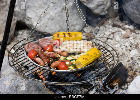 Mit einem Gitter Grillen über dem Lagerfeuer Stockfoto