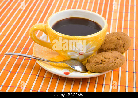 Cookies und Tasse mit Kaffee auf Bambus-Tischdecke hautnah Stockfoto