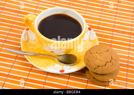 Cookies und Tasse mit Kaffee auf Bambus-Tischdecke hautnah Stockfoto