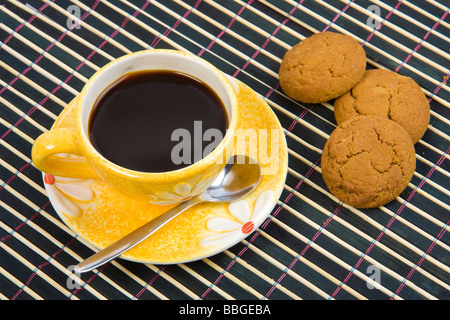 Cookies und Tasse mit Kaffee auf Bambus-Tischdecke hautnah Stockfoto
