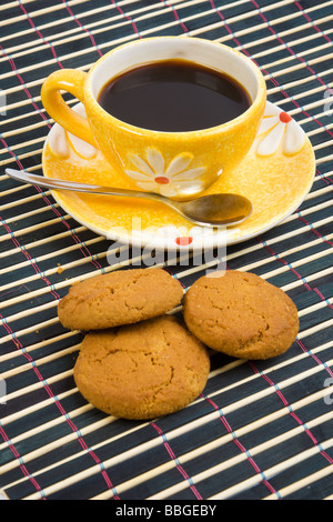Cookies und Tasse mit Kaffee auf Bambus-Tischdecke hautnah Stockfoto