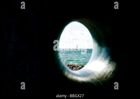 Ein Segelboot im Ärmelkanal aus UK Küste schlank durch eine Skulptur am Brighton Ufer. Stockfoto