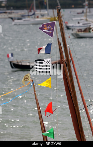 Flaggen wehen auf eine kleine hölzerne Segelschiff Mast Golfe du Morbihan, Frankreich Stockfoto