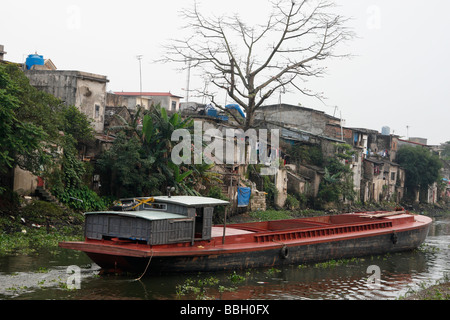 Lastkahn Boot Segeln entlang Kanal in benachteiligten Stadt Slum, 'Ninh Binh', Vietnam Stockfoto