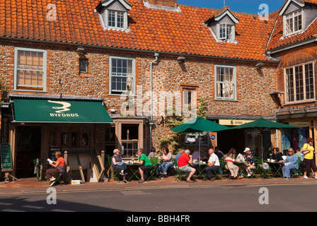 Kunden, die draußen in der Sonne trinken Tee und Kaffee im Café Byfords Feinkost Restaurant in Holt Norfolk Uk Stockfoto