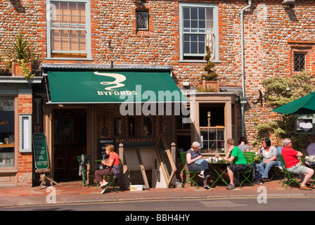 Kunden, die draußen in der Sonne trinken Tee und Kaffee im Café Byfords Feinkost Restaurant in Holt Norfolk Uk Stockfoto