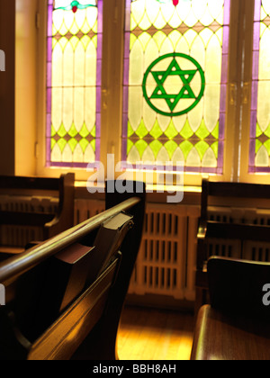 Gebetbücher auf einer Bank in einer jüdischen Synagoge Stockfoto