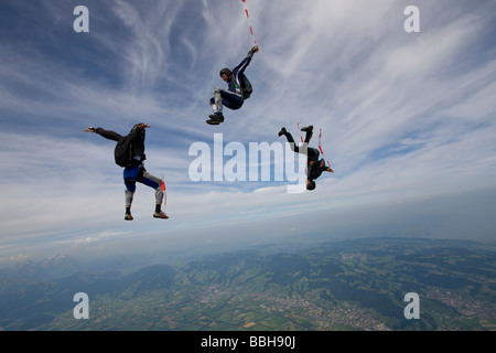 Fallschirmspringer sind innerhalb eines Teams in der Freefly-Position umeinander fliegen und Spaß über die Szenerie eine Wolke am Himmel. Stockfoto