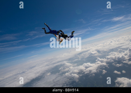 Skydive Freefly Team bildet eine spezielle HYBRID-Formation über eine spektakuläre cloud-Landschaft in den Himmel mit 130 km/h. Stockfoto