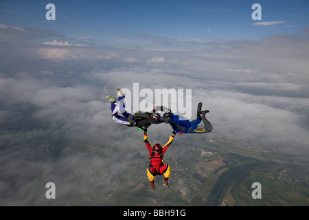 Skydive Freefly Team bildet eine spezielle HYBRID-Formation über eine spektakuläre cloud-Landschaft in den Himmel mit 130 km/h. Stockfoto