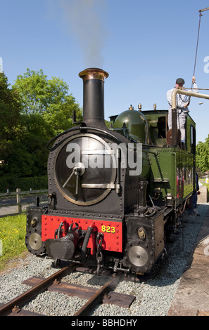 Lokomotivführer füllt die Gräfin Dampfmaschine mit Wasser aus einem Wasserturm mit einer Schmalspurbahn touristische Anziehung Stockfoto