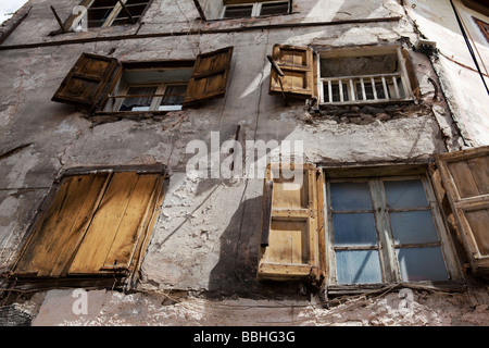 HAUS MIT BESCHÄDIGTEN FASSADE UND ZERBROCHENE FENSTERSCHEIBEN. BRIANCON, HAUTE PROVENCE, FRANKREICH Stockfoto