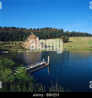 Alter Bauernhof am Rande eines Sees in der Auvergne. Frankreich. Stockfoto