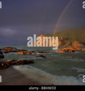 EIN REGENBOGEN WIRFT SEINEN BOGEN VON LEUCHTENDEN FARBEN IN DEN HIMMEL ÜBER DEN KÖPFEN IN KNYSNA Stockfoto