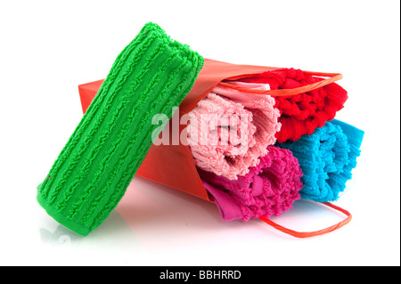 bunte Handtücher in Papiertüte isoliert auf weiß Stockfoto