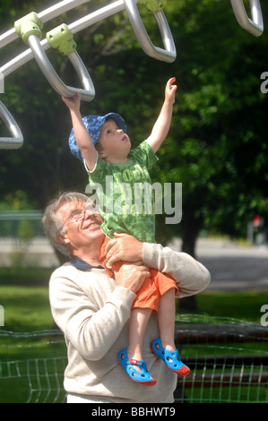 Großvater-Enkel auf einem Spielplatz zu helfen Stockfoto