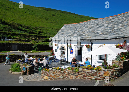 Touristen sitzen vor einem Café in der Nähe von Hafen von Boscastle, Cornwall, uk Stockfoto