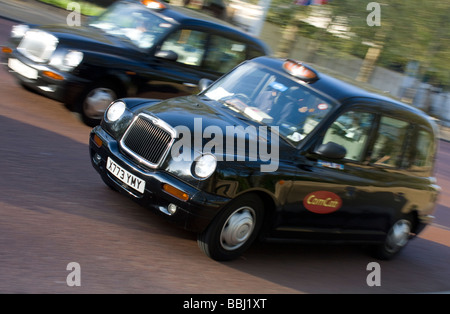 Zwei Londoner Taxis fährt entlang der Straße Stockfoto