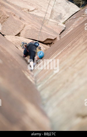 Frau klettert "Drei Streiks du bist Out" (5.11) im Indian Creek, UT. Stockfoto